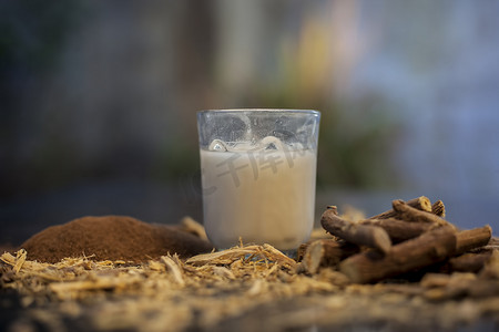 檀摄影照片_甘草阿育吠陀草药面膜，用于黑色木板上的黑斑，由一些甘草粉、檀香粉和牛奶组成。