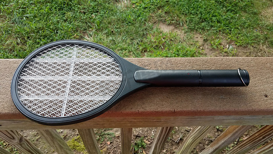 木栏杆上的电子金属网球拍杀虫剂