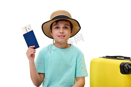 穿着蓝色 T 恤和草帽的可爱的青春期前旅行男孩，去暑假，向镜头展示登机牌