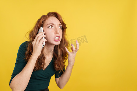 愤怒的红发女人对着手机说话