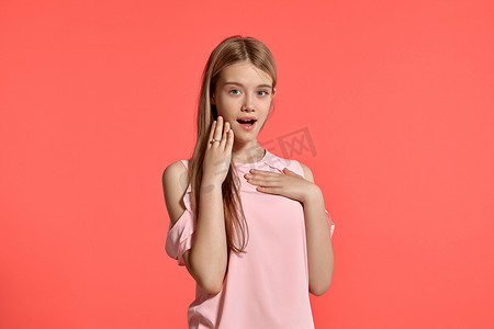 一个漂亮的金发少女的画室肖像，身穿玫瑰色 T 恤，背景为粉红色。