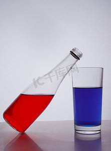 瓶和眼镜与白色背景上的五颜六色的液体组成。