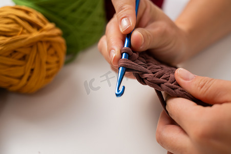 无纺编织袋摄影照片_一位女士正在编织一篮子棉纱的特写镜头。