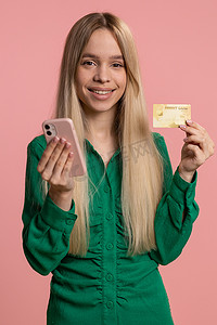 快乐的女人在转账购买网上购物时使用信用卡和智能手机