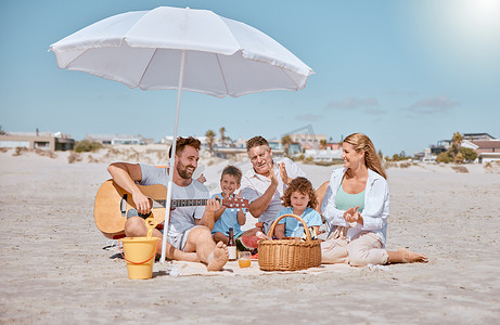 好喜欢啊摄影照片_海滩、野餐或幸福的家庭喜欢吉他音乐，同时在暑假期间结合或放松。