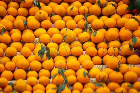 橘子 kinnu 柑橘类水果堆积在路边摊上，展示了农民如何在夏季传统上将这种当地水果作为健康食品在印度出售以供食用和榨汁