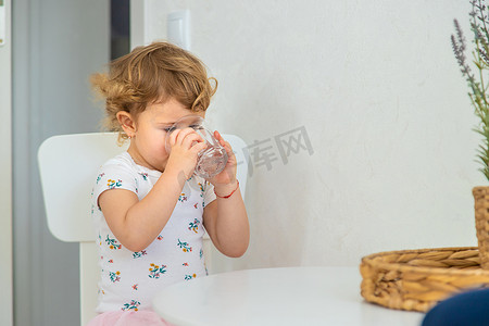 孩子从杯子里喝水。