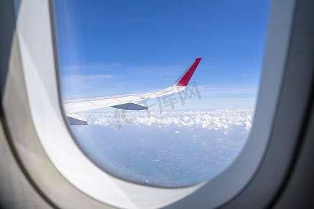 空中、地球、陆地、云与飞机窗外的飞机机翼。