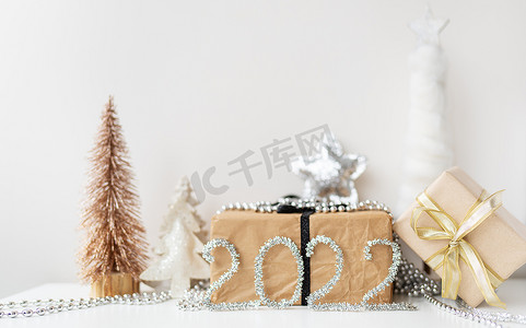 横幅 2022 年新年快乐。节日装饰 — 圣诞树、礼物、星星、金属丝。