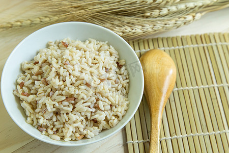糙米在木桌上的白碗中用于保健食品。