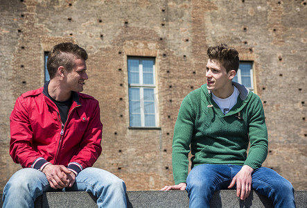 两个年轻人坐在路边聊天