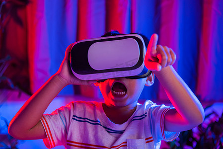 戴着虚拟现实护目镜的亚洲小孩男孩体验现实