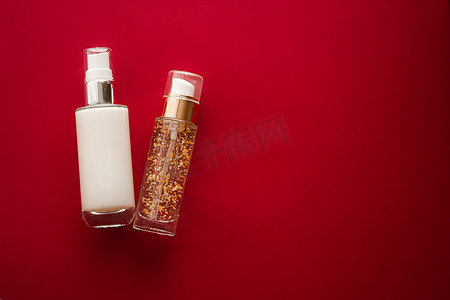 diy护肤摄影照片_红色背景中的护肤化妆品和抗衰老美容产品、豪华护肤瓶、油、血清和面霜