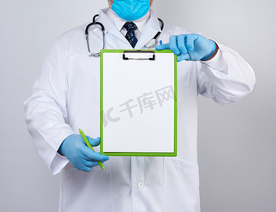 乳汁摄影照片_一件白色医疗外套和蓝色乳汁手套的男性医生拿着