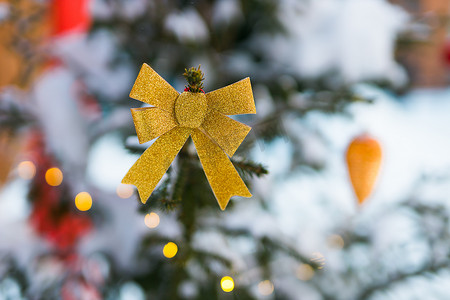 金色蝴蝶结摄影照片_带金色蝴蝶结和模糊背景复制空间的圣诞树 — 寒假和装饰