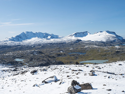 jotunheimen摄影照片_从 Krossbu 欣赏挪威西部 Jotunheimen 国家公园的 Smorstabbreen 冰川、雪山和蓝色湖泊的全景