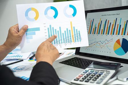 亚洲会计师在现代办公、财务和商业概念中使用图表和计算器工作和分析财务报告项目会计。
