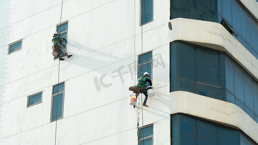 工业登山者粉刷高层墙壁和擦窗户