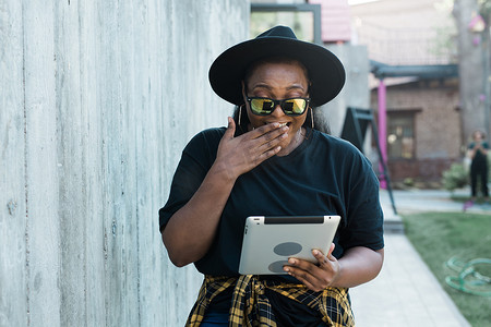 美丽的非洲裔美国女性使用数字平板电脑在户外看电影或谈论视频通话或社交网络。