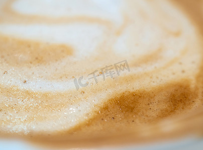 奶白色背景摄影照片_一杯咖啡中柔软细腻的奶泡的纹理表面
