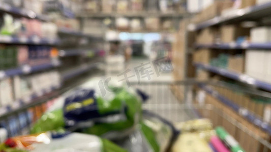 从购物车看超市里的手推车，焦点不在与在超市货架上选择产品的面目全非的人。