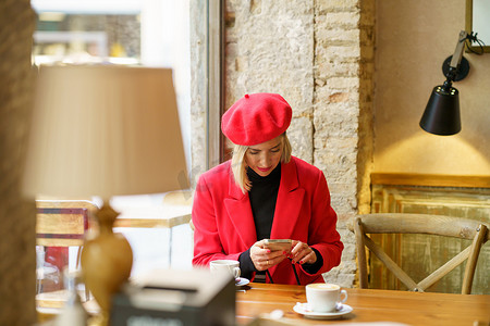 在咖啡馆浏览智能手机的优雅女性
