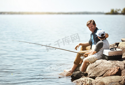 现在我们等着吃一口……一位父亲和他的小儿子一起钓鱼。