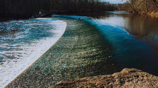 快速流动的水在冬季前冲过人造水坝