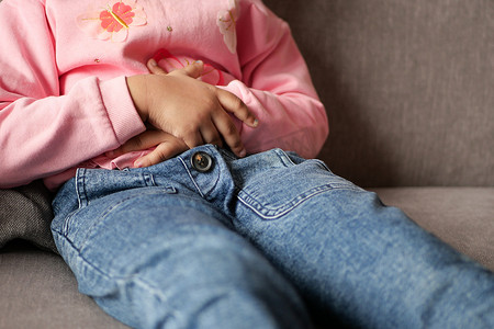 腹部痛摄影照片_患胃痛的孩子特写。