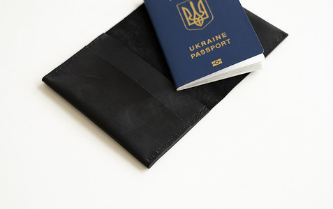 国际移民摄影照片_乌克兰生物识别护照 ID，白色背景真皮封面。