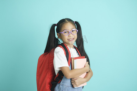 班级纪律摄影照片_戴眼镜的特写小女学生，她漂亮可爱迷人，开朗惊讶。
