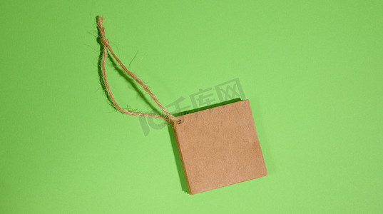 绿色背景上带绳子的棕色纸方纸标签