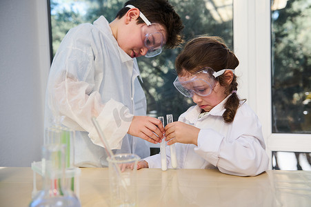 集中的聪明孩子进行化学实验，在化学课上观看试管中发生的反应