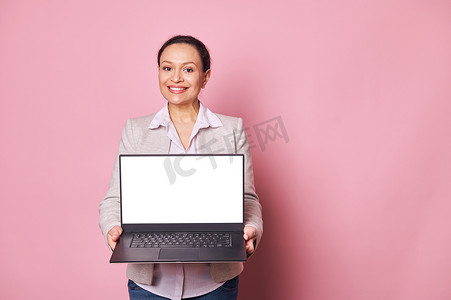 自信、积极、微笑的女商人拿着带白色空白数字屏幕的笔记本电脑，上面有移动应用的可用空间