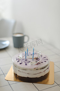 奶油生日蛋糕，白色背景上有五颜六色的洒水和蜡烛