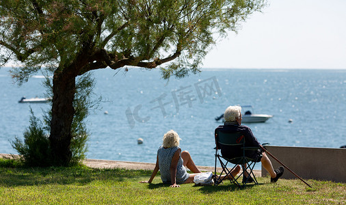 老人看海摄影照片_坐在折叠椅上看海的老人