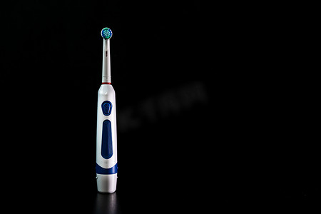 在黑色背景下隔离的电动牙刷的特写。