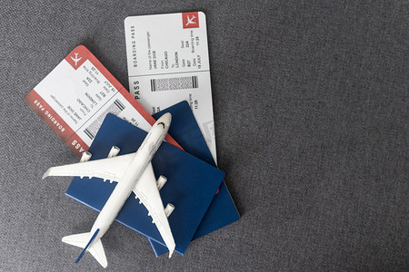 玩具飞机和护照，灰色背景，顶视图