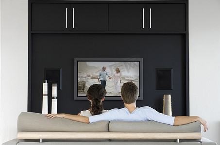 场景背影摄影照片_夫妇在客厅看电视电影的背影