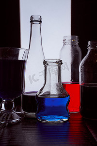 瓶装在浅色背景上，带有蓝色和红色液体剪影照片