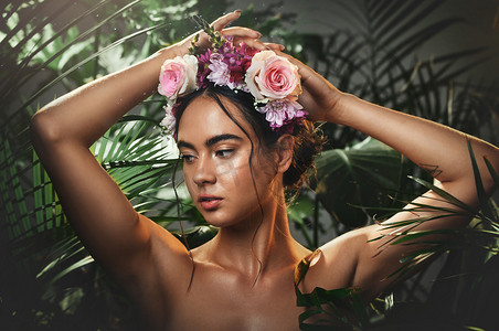 美丽、森林和一个女人的脸，她戴着花冠，站在热带树叶的背景下。