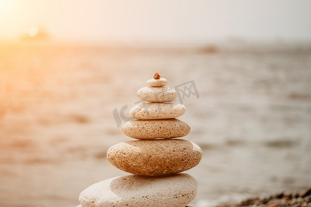 在海卵石海滩的平衡的岩石金字塔，在日落。