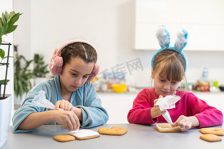快乐小孩在厨房装饰自制饼干并在家一起制作圣诞饼干的肖像