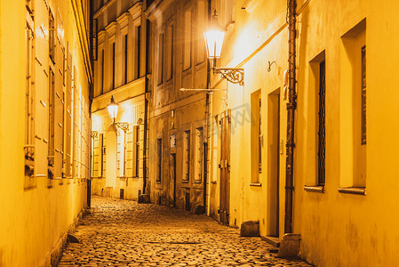 照亮黑暗摄影照片_捷克共和国布拉格老城路灯照亮的狭窄鹅卵石街道