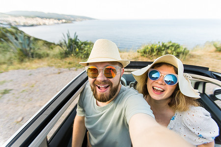浪漫的情侣在海洋或海滩上租用敞篷车在智能手机相机上自拍，一起享受暑假，周末在海边休息的手机上拍照