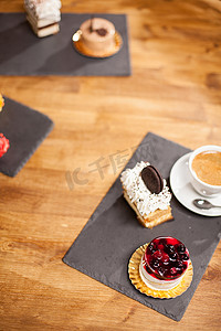 咖啡店木桌上不同迷你蛋糕附近的蛋糕和美味饼干的顶视图照片