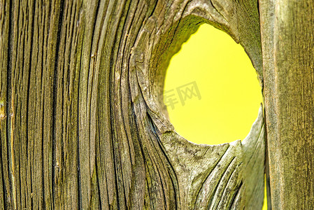 孔板摄影照片_带孔的旧木板，可以看到黄色背景