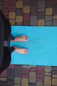 正上方面目全非的男人、瑜伽士、练习瑜伽的运动员赤脚站在健身垫上。
