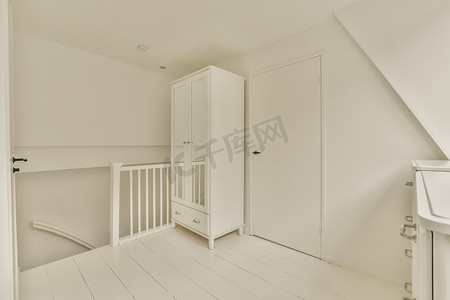 一间带衣柜和楼梯的白色小房间