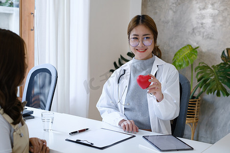 心脏病专家在私人诊所拿着红心。